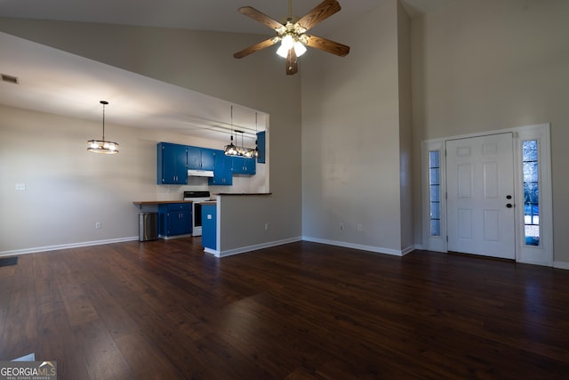 unfurnished living room featuring dark wood-style flooring, visible vents, a towering ceiling, baseboards, and ceiling fan with notable chandelier