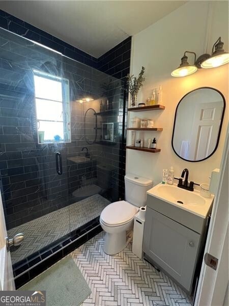 bathroom with toilet, walk in shower, and vanity