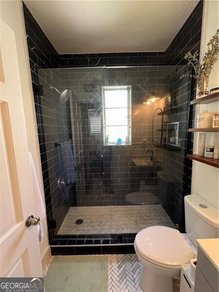 bathroom with toilet, vanity, tile patterned flooring, and a shower with door