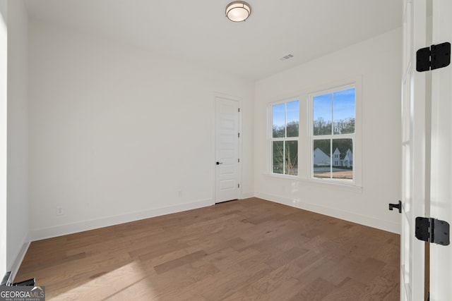 spare room with wood-type flooring