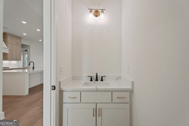 bathroom featuring hardwood / wood-style flooring, sink, and decorative backsplash