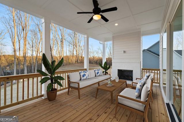 wooden terrace featuring an outdoor living space with a fireplace and ceiling fan