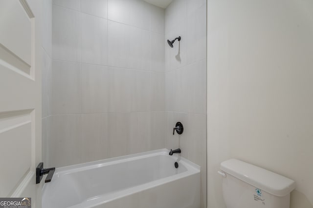 bathroom with toilet and tiled shower / bath