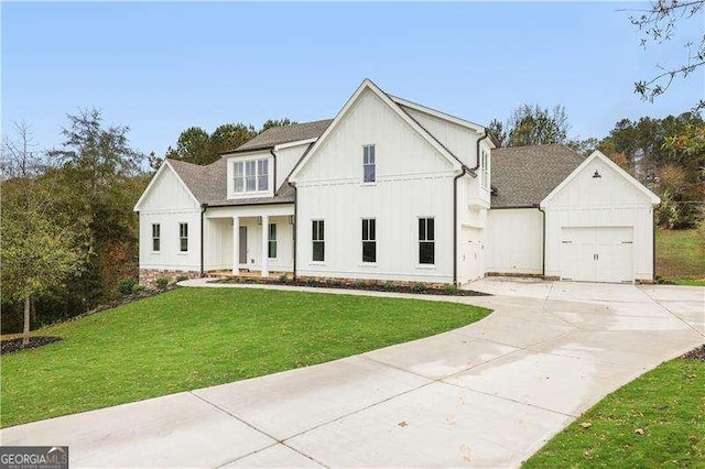 modern farmhouse style home with covered porch, a garage, and a front yard