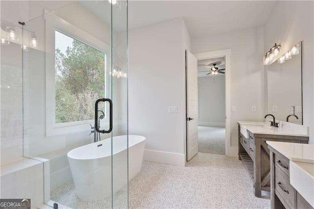 bathroom with ceiling fan, a bath, and vanity