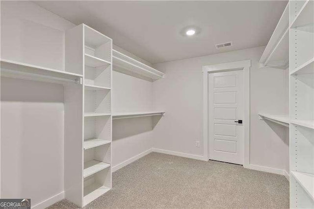 walk in closet featuring light colored carpet