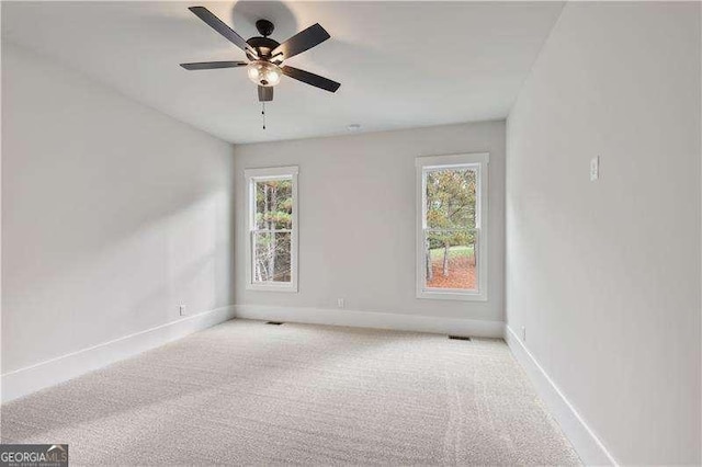 unfurnished room featuring plenty of natural light, ceiling fan, and light carpet