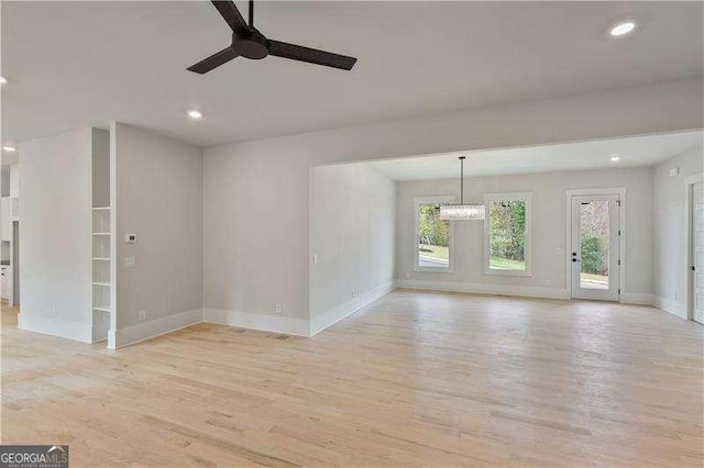 unfurnished living room with ceiling fan, light hardwood / wood-style flooring, and a healthy amount of sunlight