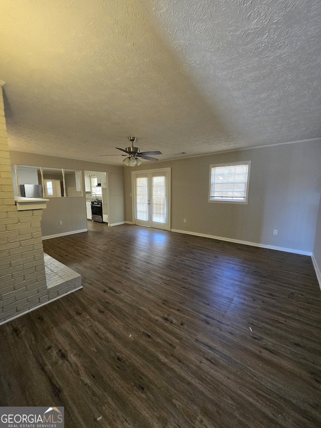 unfurnished living room with french doors, dark hardwood / wood-style flooring, a textured ceiling, and ceiling fan