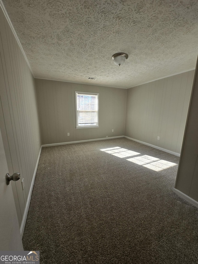 carpeted empty room with wood walls