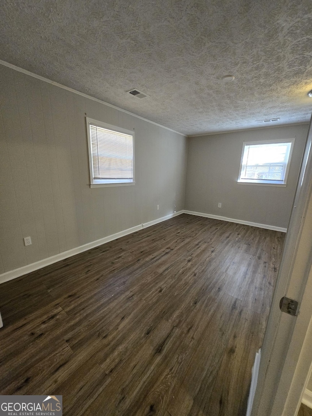 unfurnished room with dark hardwood / wood-style floors and a textured ceiling