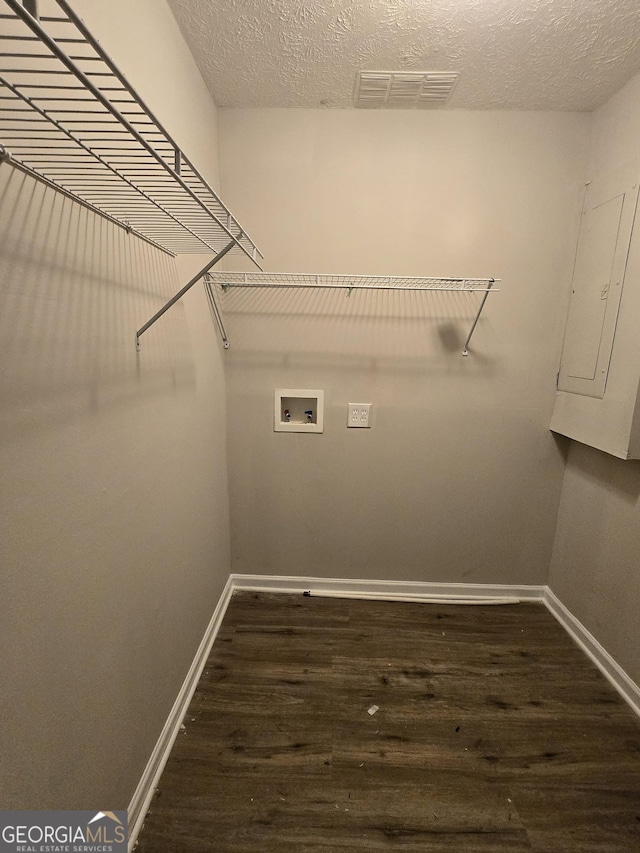 washroom featuring washer hookup, dark hardwood / wood-style floors, a textured ceiling, and electric panel