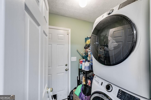 laundry room with a textured ceiling and stacked washing maching and dryer