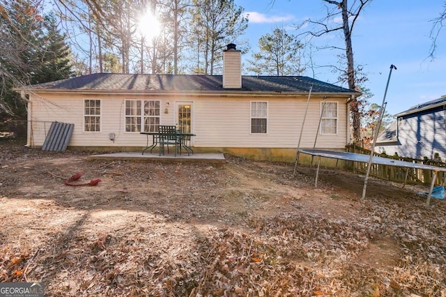 rear view of house featuring a patio and a trampoline