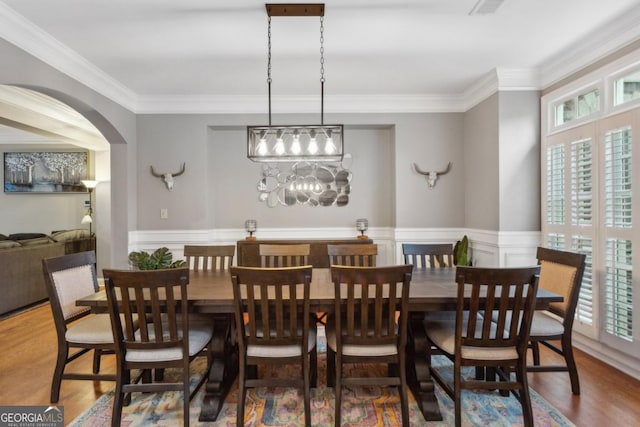 dining room with ornamental molding and hardwood / wood-style floors