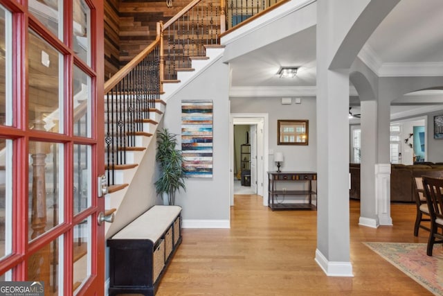 entryway with light wood-type flooring and crown molding