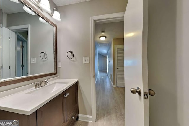 bathroom featuring hardwood / wood-style floors, vanity, and a textured ceiling