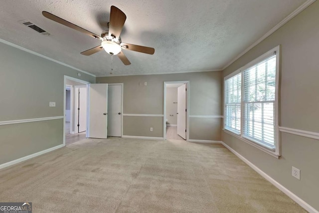 unfurnished bedroom with ceiling fan, crown molding, light carpet, and a textured ceiling