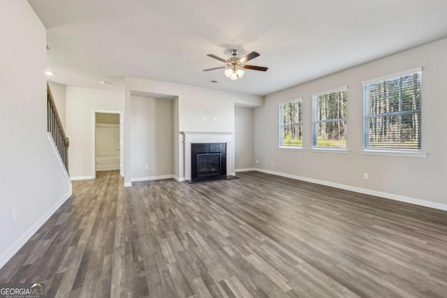 unfurnished living room featuring ceiling fan and dark hardwood / wood-style floors