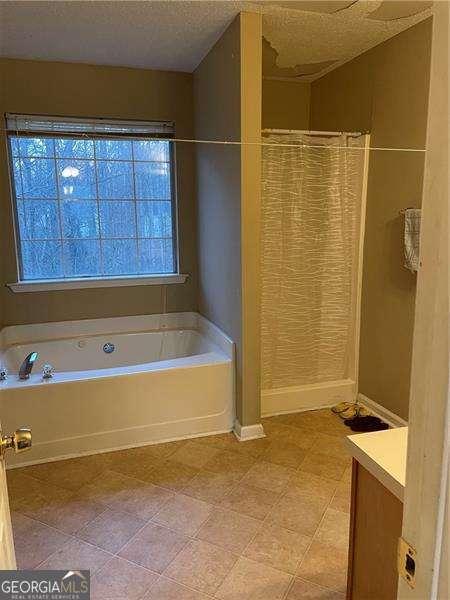 bathroom featuring vanity, shower with separate bathtub, and a textured ceiling