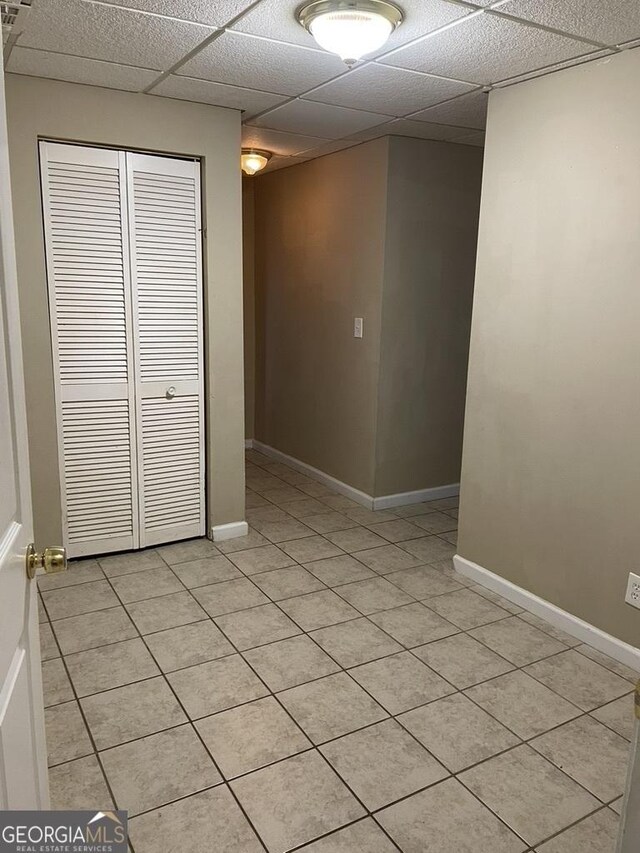 tiled spare room with a paneled ceiling