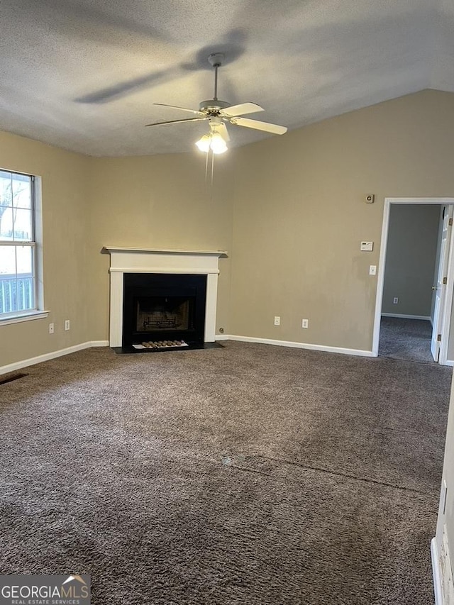 unfurnished living room featuring ceiling fan, lofted ceiling, carpet flooring, and a textured ceiling