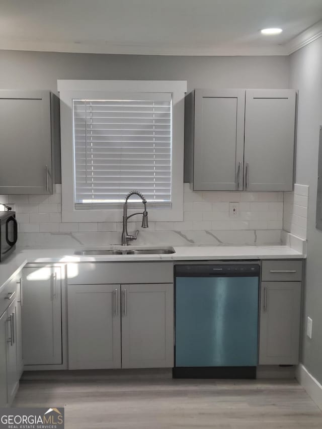 kitchen with tasteful backsplash, dishwasher, sink, and gray cabinetry