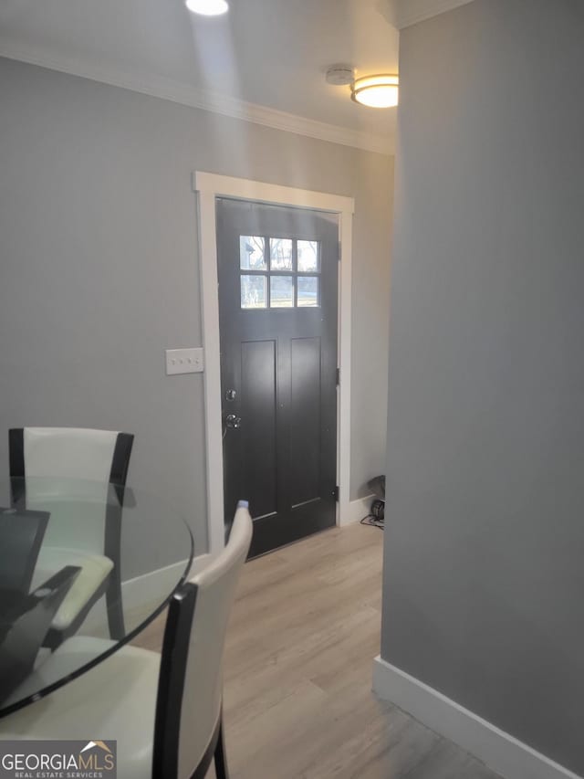 foyer entrance featuring ornamental molding and light hardwood / wood-style flooring