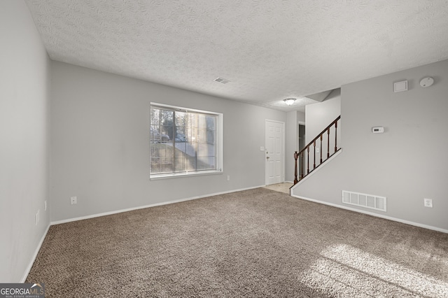 carpeted spare room with a textured ceiling