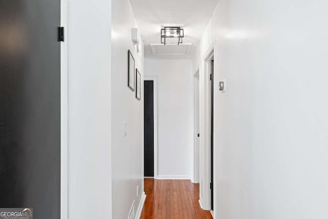 hall with hardwood / wood-style flooring and a textured ceiling