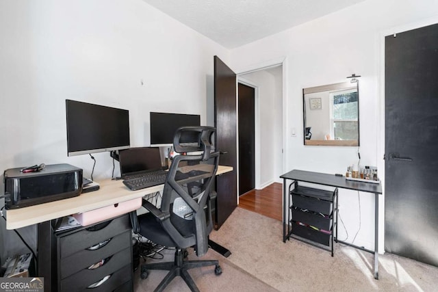 home office with a textured ceiling and light carpet