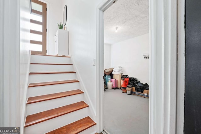 staircase with a textured ceiling