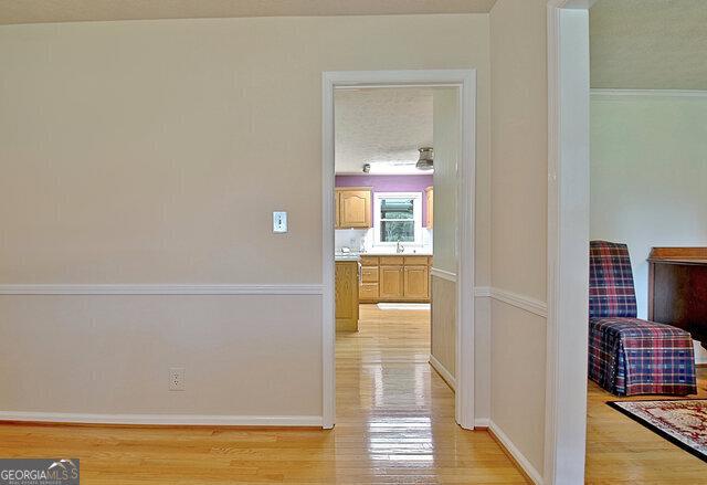 hall with light wood-type flooring and sink