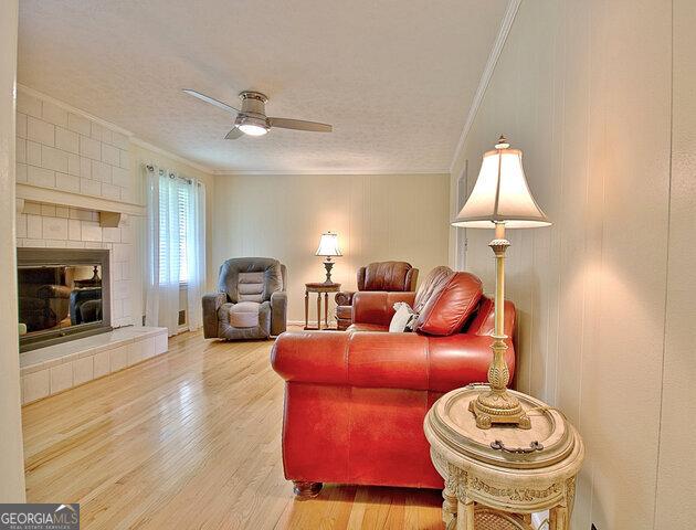 living room featuring hardwood / wood-style floors, a textured ceiling, and ornamental molding