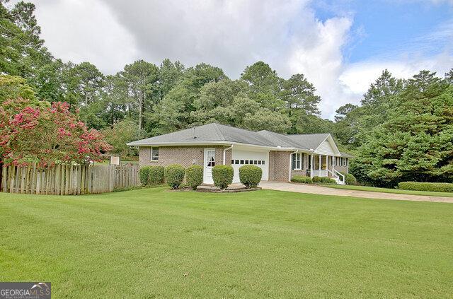 ranch-style home with a garage and a front yard