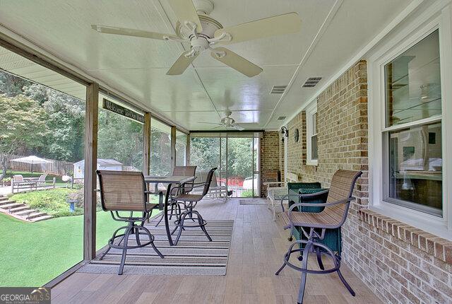 sunroom / solarium featuring ceiling fan