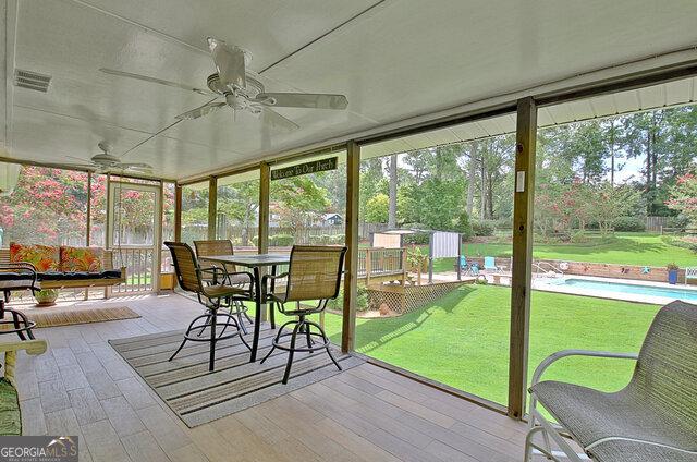 unfurnished sunroom with ceiling fan