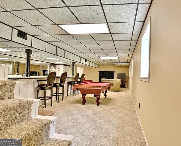 recreation room with light carpet, bar, a drop ceiling, and pool table