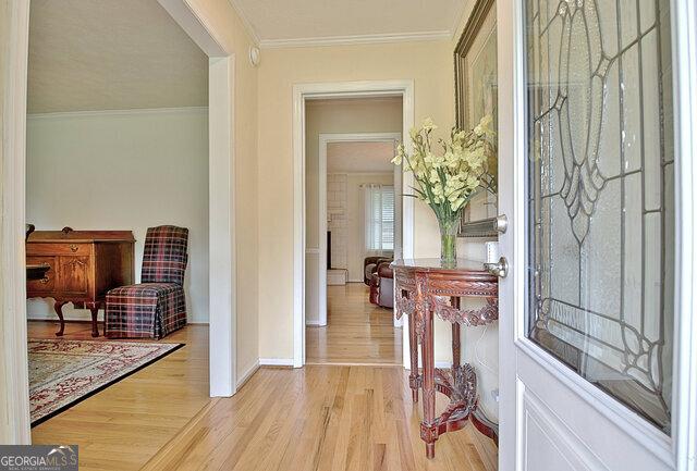 entrance foyer featuring ornamental molding and light hardwood / wood-style flooring