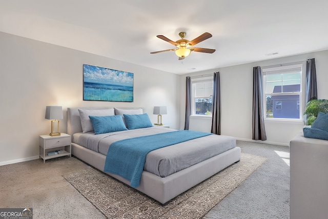 carpeted bedroom featuring ceiling fan and multiple windows