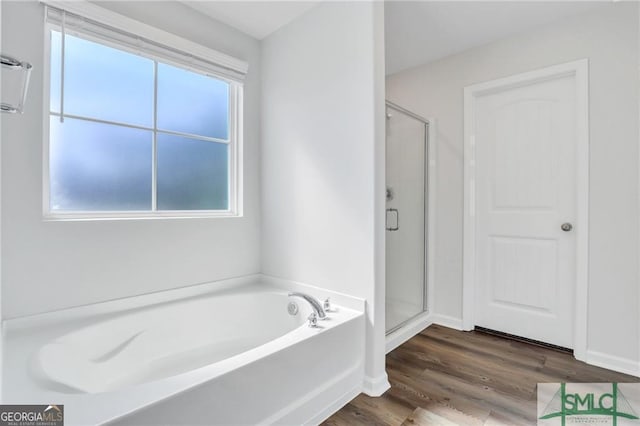 bathroom with hardwood / wood-style floors and independent shower and bath