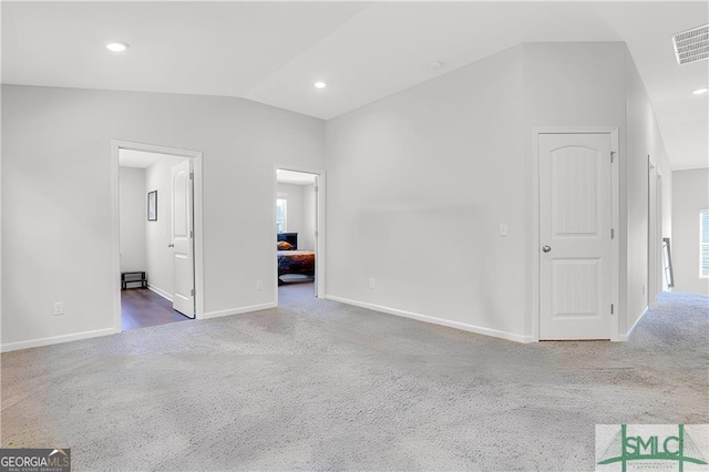 empty room featuring carpet and lofted ceiling