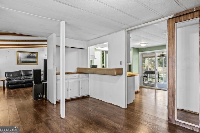 kitchen featuring dark hardwood / wood-style flooring, white cabinets, and vaulted ceiling