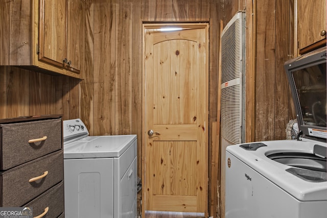 laundry area with wooden walls, cabinets, and washer / clothes dryer