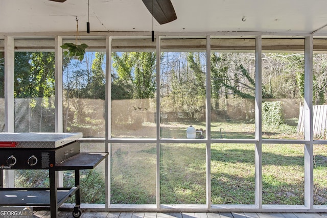 unfurnished sunroom featuring ceiling fan and a healthy amount of sunlight