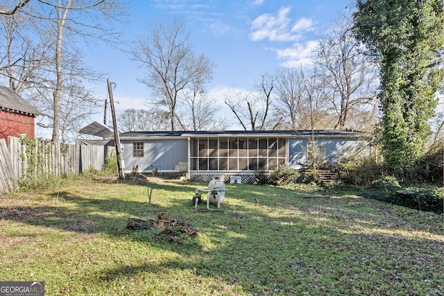 rear view of house with a sunroom and a lawn