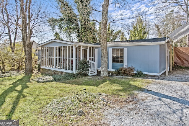 view of front of house featuring a sunroom and a front yard