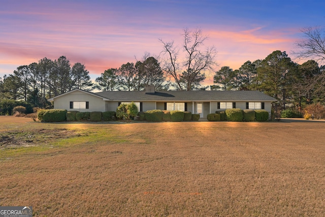 single story home with a lawn