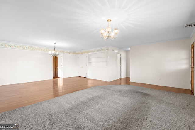 carpeted spare room featuring a notable chandelier