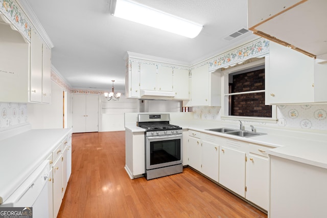 kitchen with gas range, white cabinetry, sink, and decorative light fixtures